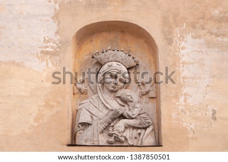 Bas-relief Virgin Maria with child on beige vintage  background. Face mother with baby. 