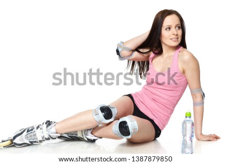 The beautiful young woman in rollerskates on a white background.