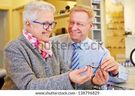 Happy senior couple buying new glasses at the optician Royalty-Free Stock Photo #138796829