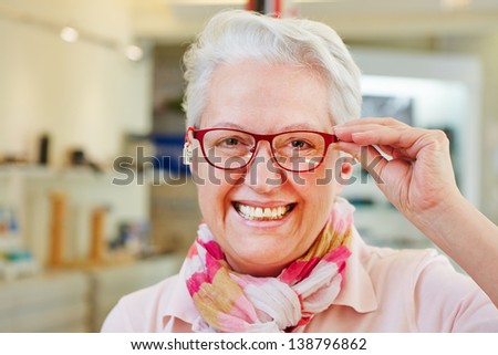 Happy senior woman with new glasses at optician retail store Royalty-Free Stock Photo #138796862