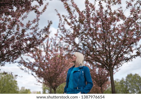 Young blonde mother woman enjoying free time - Dressed in blue jacket and white pants