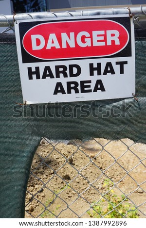 danger hard hat sign on construction site                               