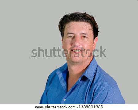 corporate portrait of young attractive and confident entrepreneur man in casual shirt smiling happy and positive looking at the camera in business success isolated on studio background
