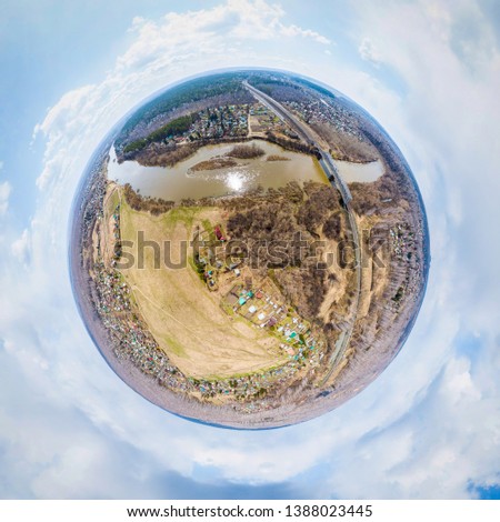 Helicopter drone shot. Aerial photography of a  over an area,  large village with small houses,, a green forest and a large field in a warm sunny summer day. Panoramic city 360  shot from above