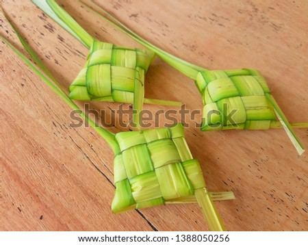 Ketupat (rice dumpling) on wooden background. Ketupat is most popular food on Aidilfitri festival (Fasting Day of Celebration for Muslim)