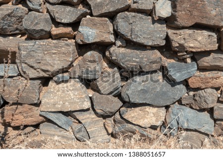 Old heaped stone wall for background
