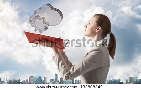 Woman looks at transparent cloud and snowflake 3d symbols above opened notebook. Online meteorology, weather forecast service. Elegant girl with book on background of cityscape and cloudy blue sky.