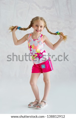 Pretty smiling girl with pigtails wearing summer sports outfit