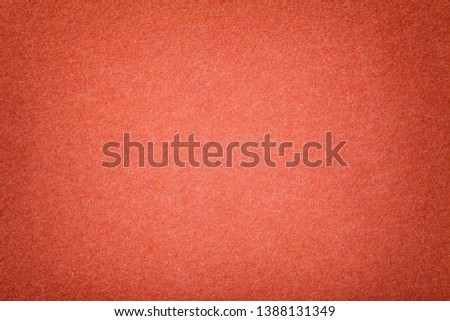 Dark orange matte background of suede fabric, closeup. Velvet texture of seamless red woolen felt. Gradient backdrop