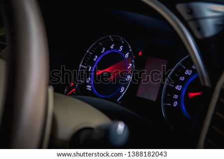 Speedometer scoring high speed in a fast motion. Sporty Car Dashboard Instruments illuminated at night. Rev counter. Modern Vehicle cluster Royalty-Free Stock Photo #1388182043