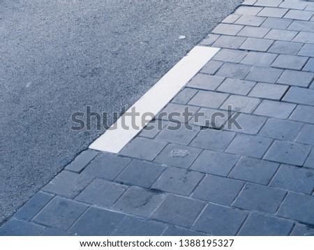 White line painted on the asphalt of a street to separate two lanes.