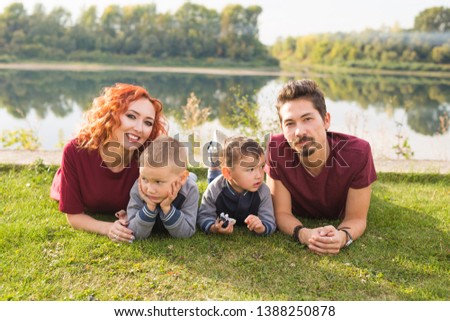 Children, parenthood and nature concept - Big family lying on the grass