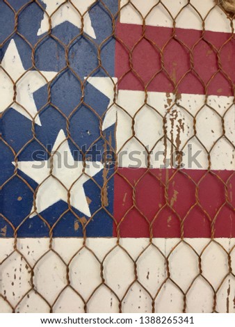 Rustic painted American flag sign with chicken wire overlay