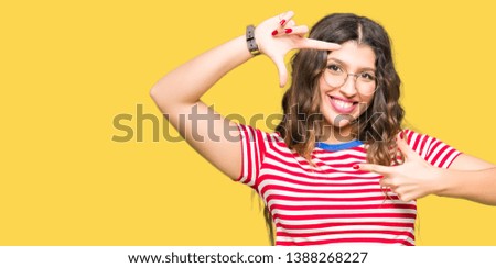 Young beautiful woman wearing glasses smiling making frame with hands and fingers with happy face. Creativity and photography concept.