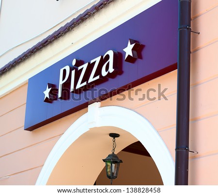 sign saying pizza, hung at the entrance to the cafe