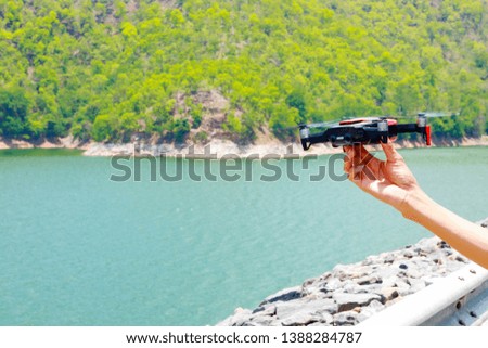 drone with the professional camera takes pictures of the reservoir in the mountains