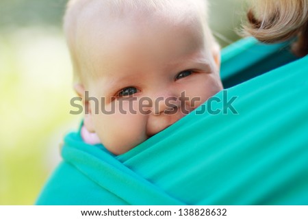 Smiling baby closed to mom in sling outdoor Royalty-Free Stock Photo #138828632