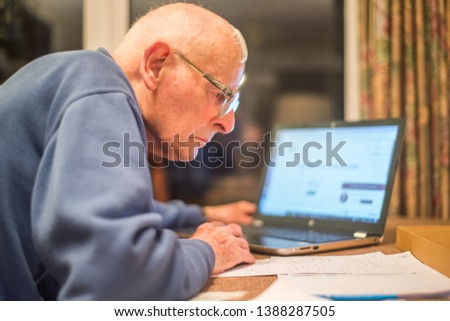 Old man of 93 years having trouble using his computer to check his finances online,very challenging for old people. Royalty-Free Stock Photo #1388287505