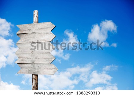 wooden signpost on a background of blue sky with clouds
