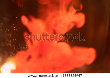 A drop of red ink dissolving in water