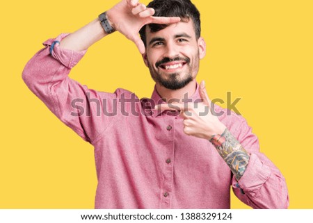 Young handsome man wearing pink shirt over isolated background smiling making frame with hands and fingers with happy face. Creativity and photography concept.