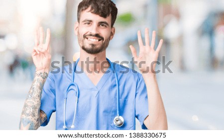 Young handsome nurse man wearing surgeon uniform over isolated background showing and pointing up with fingers number eight while smiling confident and happy.