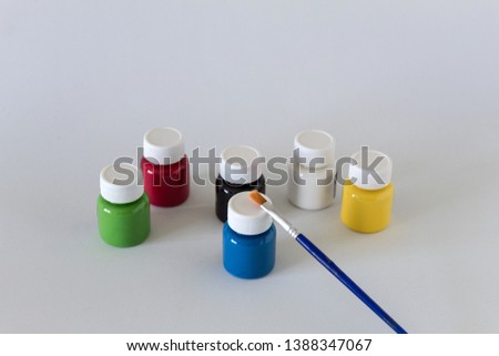 Colorful paints and brush isolated on white background