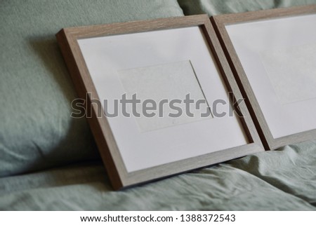 Mockup-template. Twp photo frames in pastel green bed sheet. Frames with white copy space, cozy feeling ideal for furniture/decoration shoot-outs.