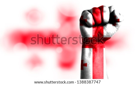 Flag of Georgia painted on male fist, strength,power,concept of conflict. On a blurred background with a good place for your text.