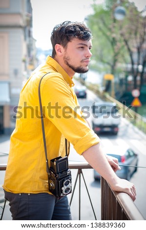 hipster young man with old camera on the balcony