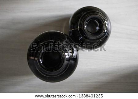 Birds eye view of two empty black vases in natural light.