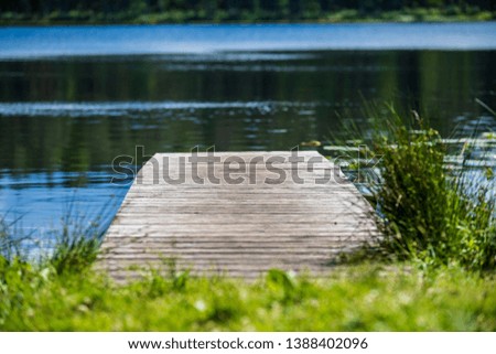 wooden plank foothpath boardwalk trampoline in the lake with blue water in summer