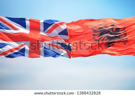 Flags of the United Kingdom and Albania on the background of blue sky