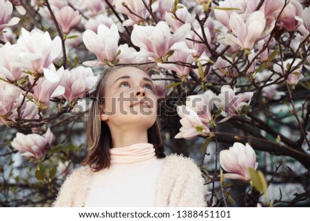 Young beautiful girl relax in beautiful garden. Fantastic pink Magnolia