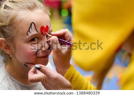 The animator paints the face of the child. Royalty-Free Stock Photo #1388480339