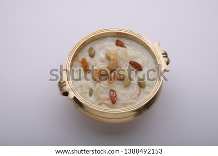 vermicelli payasam /kheer- sweet dish made in special occasions mostly in india which is well garnished with cashew nuts,kismiss and almonds in brass vessel  in southindian style with white backgrond
