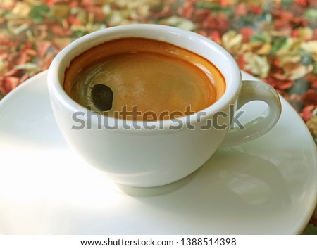 Hot Black Coffee in a White Cup Served on Flower Pattern Table Cloth