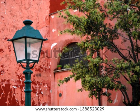 ancient red Pompeian farmhouse surrounded by garden lanterns and trees Royalty-Free Stock Photo #1388523029