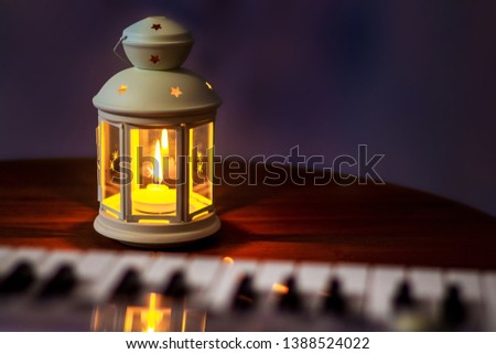 Lantern with a candle near the piano. Evening concert. Performing music in a romantic setting