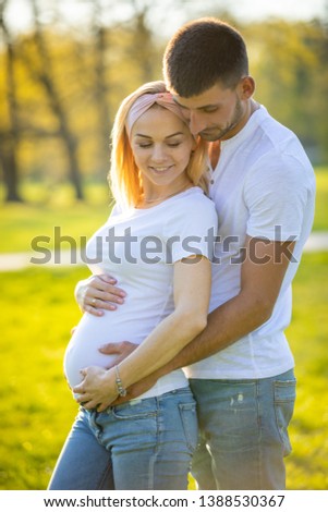 Happy couple expecting baby, pregnant young woman with husband, young family and new life concept