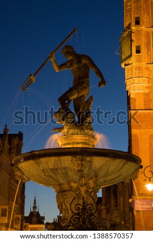 The Statue of Neptune in the centre of Gdansk, with a sundial in the background.