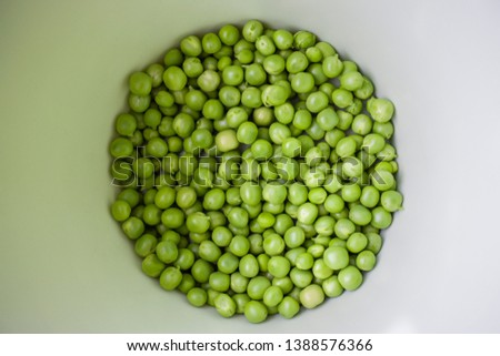 Green pea closeup in a bowl. Horizontal photo of peeled peas on the market bench / counter / stand. Vegetable of summer season. 