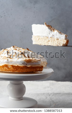 Cottage cheese lemon pie (cake) with meringue on cake stand, white and grey background