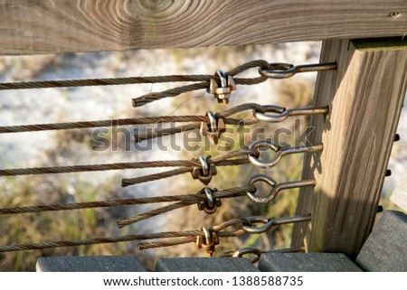 Metal Cable Hardware on Wooden Boardwalk Beams With Rusted Texture
