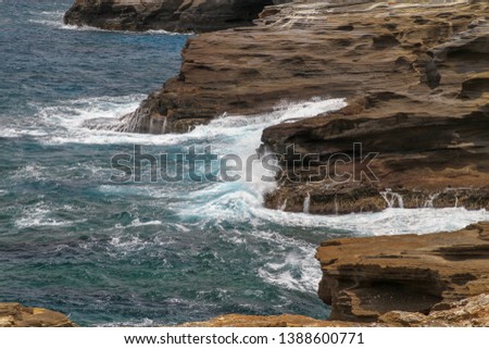waves break on rocks at the coastline