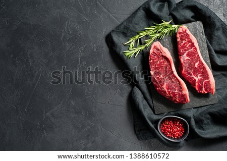 Raw beef ramp steak. Black background, top view Royalty-Free Stock Photo #1388610572