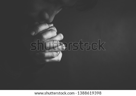 Praying man hoping for better. Asking God for good luck, success, forgiveness. Power of religion, belief, worship. Holding hands in prayer, eyes closed. Royalty-Free Stock Photo #1388619398