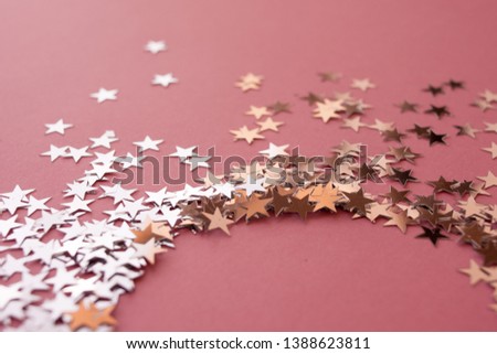 Star-shaped confetti scattered on a pink background. Celebration and party, concept. Copy space, glitter in the shape of a circle