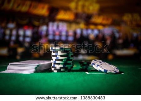 Cards and chips on green felt casino table. Abstract background with copy space. Gambling, poker, casino and cards games theme. Casino elements on green. Selective focus