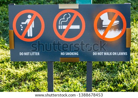 Don't litter Sign. Do not walk on the lawns Sign. No smoking sigh in the city